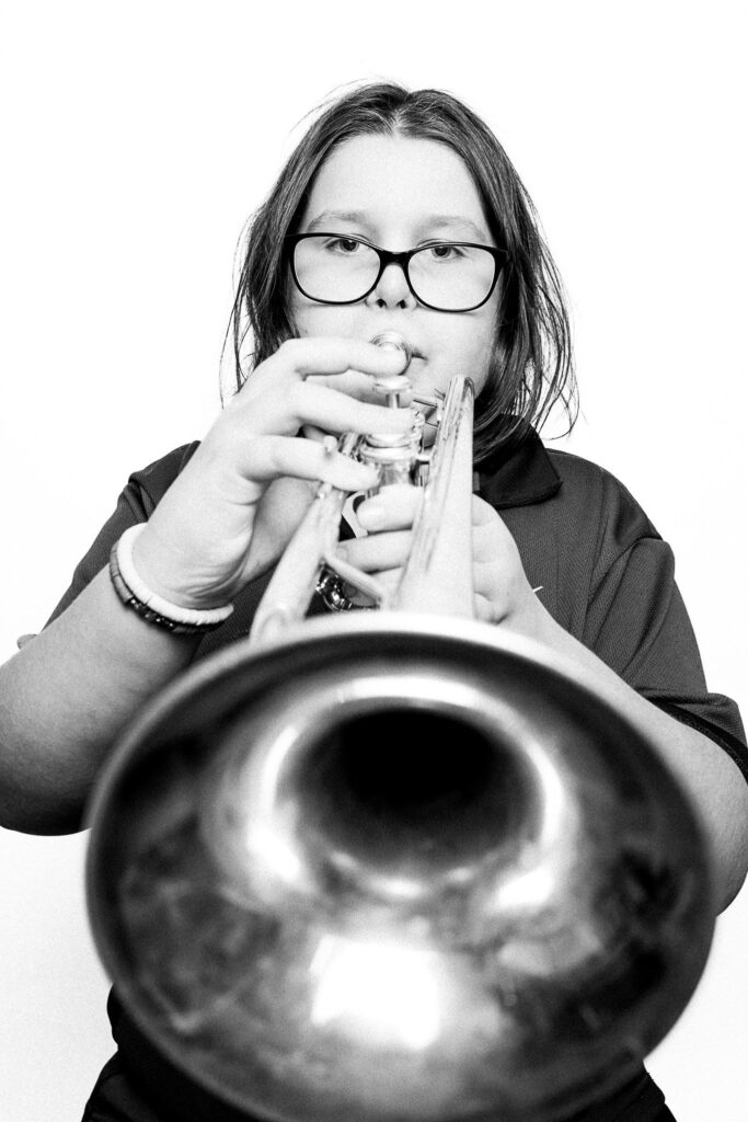 Black and white photograph of a young musician playing the trumpet. 
